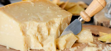 Bıçakla kesilmiş parmesan peyniri. İtalyan yemek geçmişi. Kapat.
