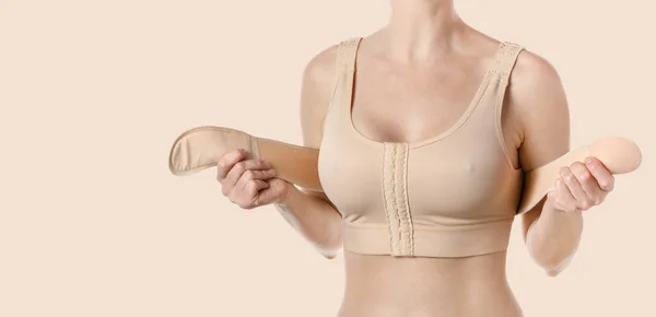 stock image Young woman wearing a compressing bra with a stripe after breast augmentation surgery. 