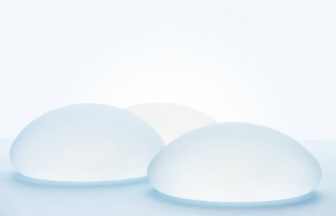 Breast implants on blue background. clipart