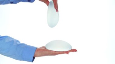 Beyaz arka planda göğüs implantı gösteren bir kadın. Estetik ameliyat, göğüs büyütme.. 