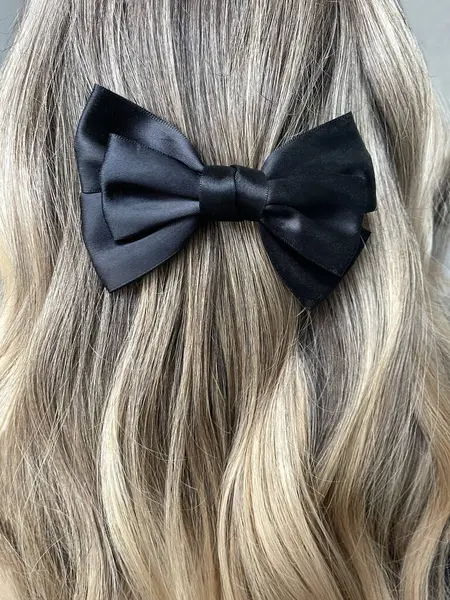 Black hair bow on dyed hair in air touch technique.