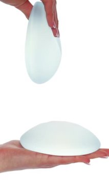 Beyaz arka planda göğüs implantı gösteren bir kadın. Estetik ameliyat, göğüs büyütme.. 