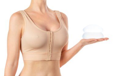 Göğüs implantı tutan, sıkıştırılmış sutyen takan kadın portresi.