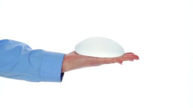 Göğüs implantları elinde. Estetik ameliyat.
