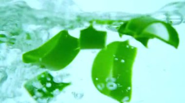 Cam kabı aloe vera dilimleriyle dolduran su. Makro video.
