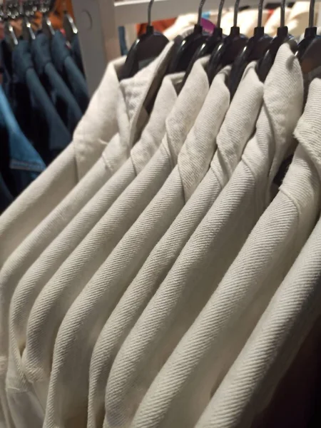 衣料品店でハンガーに白いシャツ — ストック写真