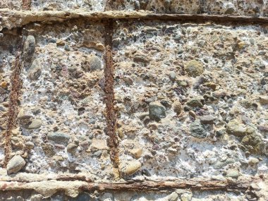 Hasarlı beton duvar ve korunmasız paslı çelik demirler.