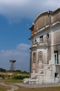 Mavi pencereli terk edilmiş bir bina ve duvarlarında açık pas izleri var. Bokor Ulusal Parkı, Kamboçya.