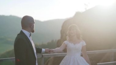 İnanılmaz manzara manzarasında, birbirlerine sarılırlar ve büyük kayalıkların ve kayaların arka planında romantik hissederler. Çift gün batımında ağır çekimde dans ediyor. Yüksek kaliteli FullHD görüntüler