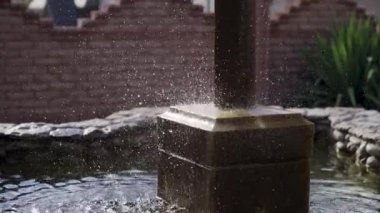 Doğal taşların üzerinde süslü bir şelale ve mavi gökyüzü kartal heykeli. Yavaş çekim düşüyor. Yüksek kaliteli FullHD görüntüler