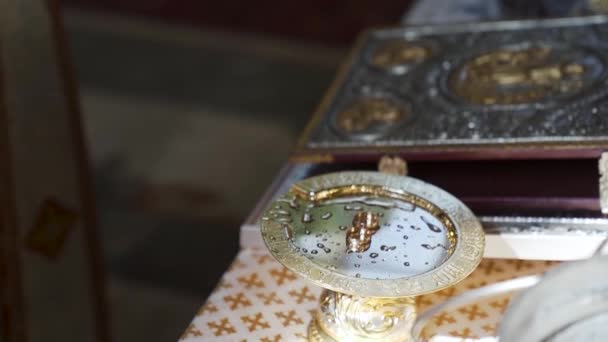 金の皿の上に結婚指輪 ソフトフォーカス花嫁の教会結婚式 高品質のフルHd映像 — ストック動画