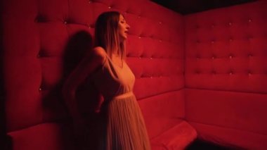 Gece kulübünün kırmızı odasında, kanepede şarkı söyleyen genç bir kız. Müzik videosu çekiyoruz. Yüksek kalite 4k görüntü