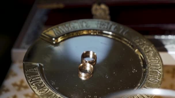 金の皿の上に結婚指輪 ソフトフォーカス花嫁の教会結婚式 高品質のフルHd映像 — ストック動画