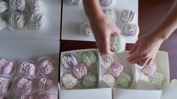Een Vrouw Verpakt Delicate Lichtgroene Roze Marshmallows Een Geschenkdoos Nabijgelegen — Stockvideo