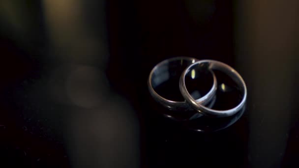 Dois Anéis Casamento Estão Sobre Mesa Iluminados Por Feixe Luz — Vídeo de Stock