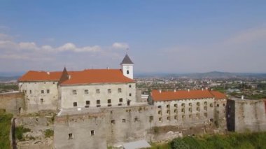 İnsansız hava aracı, bulutlu bir sonbahar gününde, Avrupa 'nın küçük bir şehrinde, Ortaçağ kalesinde, Palanok Şatosu, Mukachevo, Ukrayna' da saat kulesinin üzerinde uçuyor. Yüksek kalite 4k görüntü