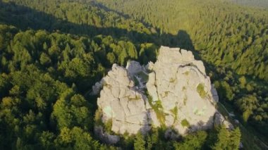 Tustan kalesinin havadan görünüşü. İnsansız hava aracı, ormanın arka planındaki güzel kayaların yanında uçuyor. Lviv bölgesi, Ukrayna. Gün batımı manzarası. Yüksek kalite 4k görüntü