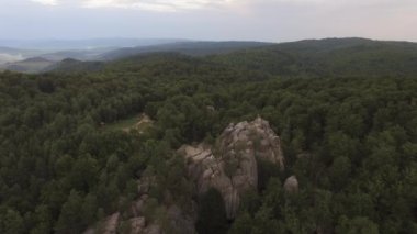 Dağların üzerinden uçmak, günbatımı, ormanın üzerinden uçmak, dağların üzerinden uçmak, güvercin havası, kayaların üzerinden uçmak. Yüksek kalite 4k görüntü