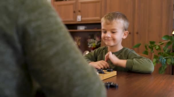 家で小さな男の子と彼の祖母がチェッカーをしています 高品質4K映像 — ストック動画