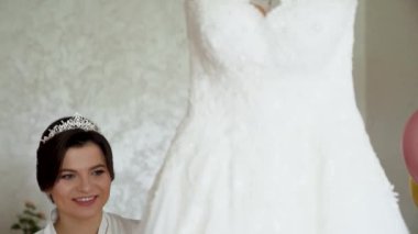 Bride In Silk Dressing Gown Holding And Admiring Her Beautiful Wedding Dress. High quality FullHD footage
