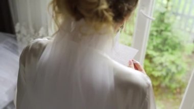 Young woman in white lingerie reading letter indoors. High quality FullHD footage