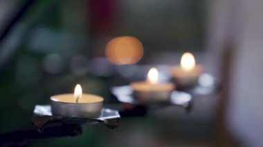 Many tea lights candles burning in a Christian church chapel. Close up shot, no people. High quality FullHD footage