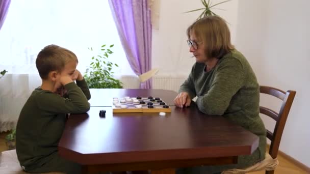 Grandmother Little Grandson Play Checkers Sit Table Multi Generational Family — Stock Video