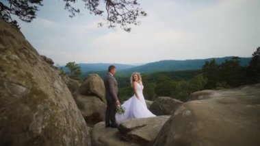 Couple standing on top of mountain. Strong wind and sunset. High quality FullHD footage