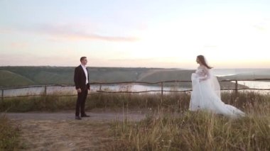 The bride runs into the grooms arms in river background on slow-motion. High quality FullHD footage