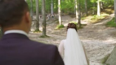 Dağlarda genç bir çift. Kayaların arasında yürüyen yeni evliler. Ağır çekim. Yüksek kaliteli FullHD görüntüler