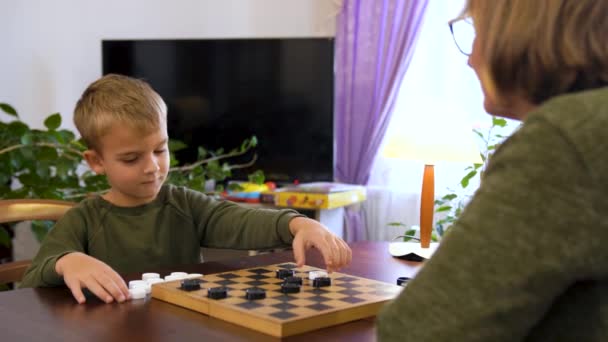 Ein Kleiner Junge Spielt Mit Der Großmutter Damesteine Der Junge — Stockvideo