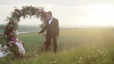 wedding arch on the edge of a cliff on the background of the river. High quality FullHD footage