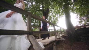 Lovely wedding couple in the forest. The bride kisses the groom. Slow motion. High quality FullHD footage