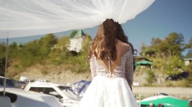 Rüzgarda savrulan beyaz bir duvak. Yatın yanında duran bir çift. Ağır çekim. Yüksek kaliteli FullHD görüntüler