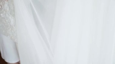 Bride In Silk Dressing Gown Holding And Admiring Her Beautiful Wedding Dress. High quality FullHD footage