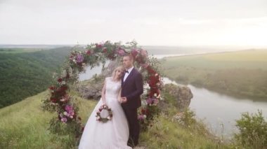 wedding arch on the edge of a cliff on the background of the river. High quality FullHD footage