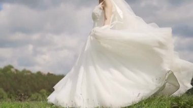 Gorgeous bride dancing against the background of a clouds. Slow motion. High quality FullHD footage