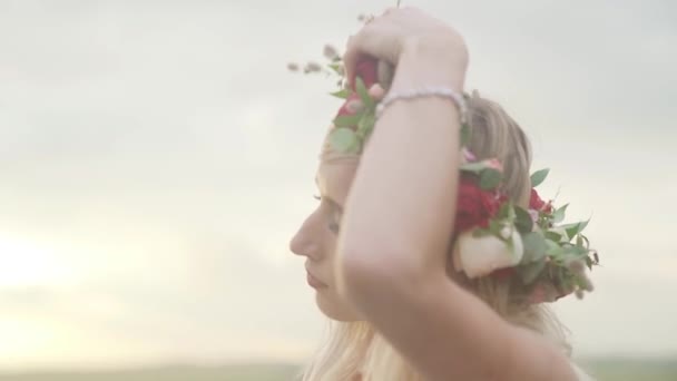 日没時には 丘の上を歩く白人の美しいセクシーな女の子と花輪を削除します 髪に太陽の光の線 魔法を使う 芸術的な効果は 太陽光です 高画質映像 — ストック動画