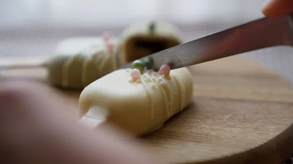 Yakın çekim. Kadın, Cheesecake 'i ahşap tabakta dondurma şeklinde kesti. Yüksek kalite 4k görüntü