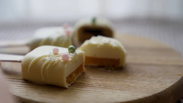 Yakın çekim. Kadın, Cheesecake 'i ahşap tabakta dondurma şeklinde kesti. Yüksek kalite 4k görüntü