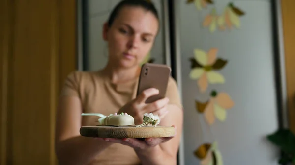 Young woman taking photos with tasty chocolate cake holding cake posing to camera. Woman enjoying travel on vacation at cafe shop. High quality 4k footage