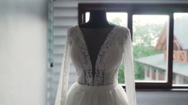 Silhouette wedding dress standing on mannequin in front of the window. High quality FullHD footage