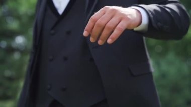 Yakından seksi bir adam park yerinde daha iyi papyon takıyor. Dışarıdaki kameraya bakan seksi erkek portresi. Büyüleyici damat bahçede kendini gergin hissediyor. Yüksek kaliteli FullHD görüntüler