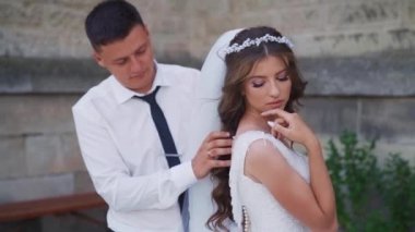 Gülümseyen çift, adam gelinin eline dokunuyor, beyaz duvak. Yüksek kaliteli FullHD görüntüler