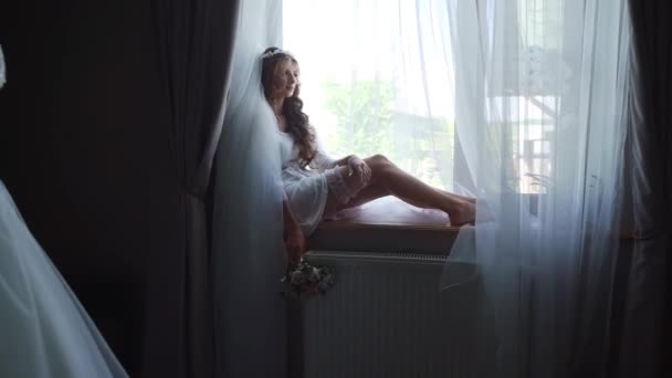 ポートレート大人の美しいブロンドの女の子プリンセスは花束で窓辺に座っている 大きなパノラマ窓からの景色を楽しむ若い女性 繊細なメイクかわいい顔優しいメイク 高品質フルHd — ストック動画
