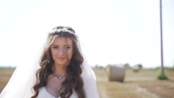 麦畑の上に藁玉でポーズをとったボヘミアンの女の子の肖像 スローモーション 高品質のフルHd映像 — ストック動画
