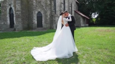 Düğün günlerinde genç bir çift. Damat kalenin yanındaki geline yaklaşıyor. Şefkat anı. Yüksek kaliteli FullHD görüntüler