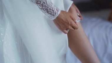 İç etekli seksi bir gelinin pencerenin yanında jartiyer giydiği yakın plan bir fotoğraf. Yüksek kaliteli FullHD görüntüler