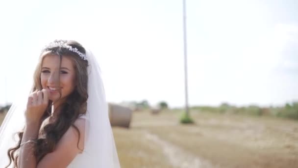 麦畑の上に藁玉でポーズをとったボヘミアンの女の子の肖像 スローモーション 高品質のフルHd映像 — ストック動画