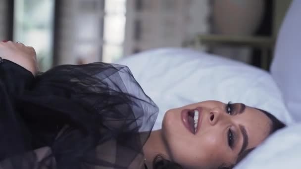 穿着黑色衣服的性感女人唱着歌躺在床上音乐录影带4K 高质量的4K镜头 — 图库视频影像